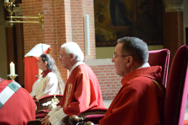 pastoor zittend op priesterkoor